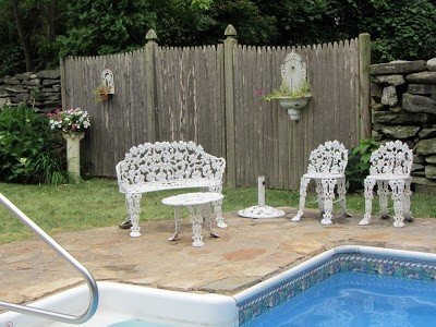 Furniture on at the near end of the pool is