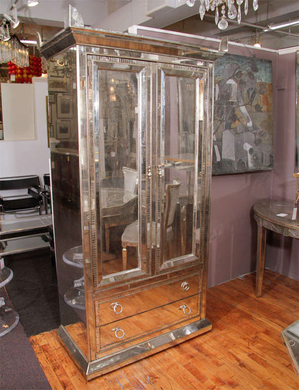 Mirrored armoire wardrobe with decorative hinged handles and pointed