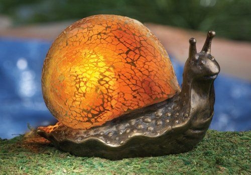 Solar lighted mosaic garden snail lamp along top of front
