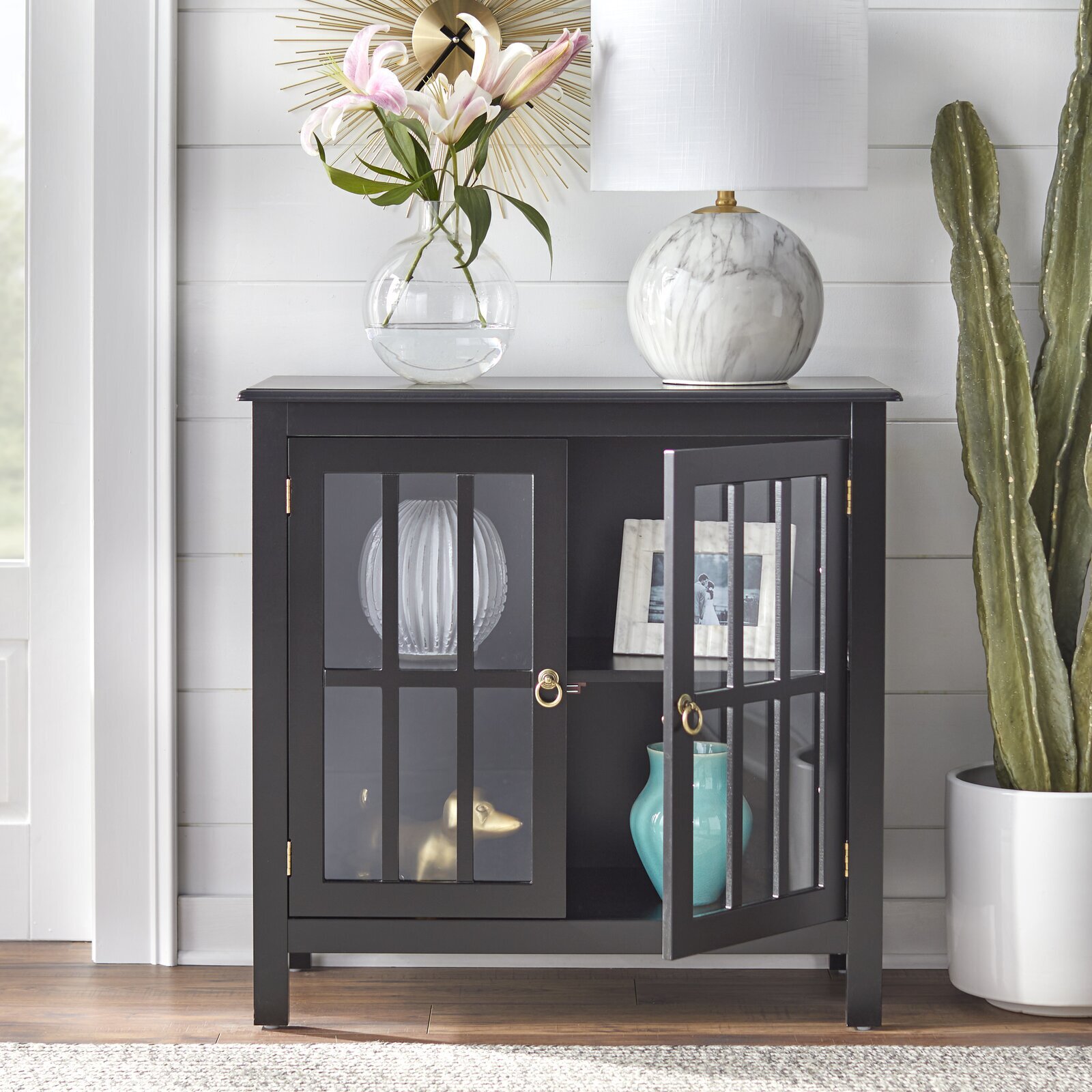 A gorgeous black painted minimalist cabinet with glass doors