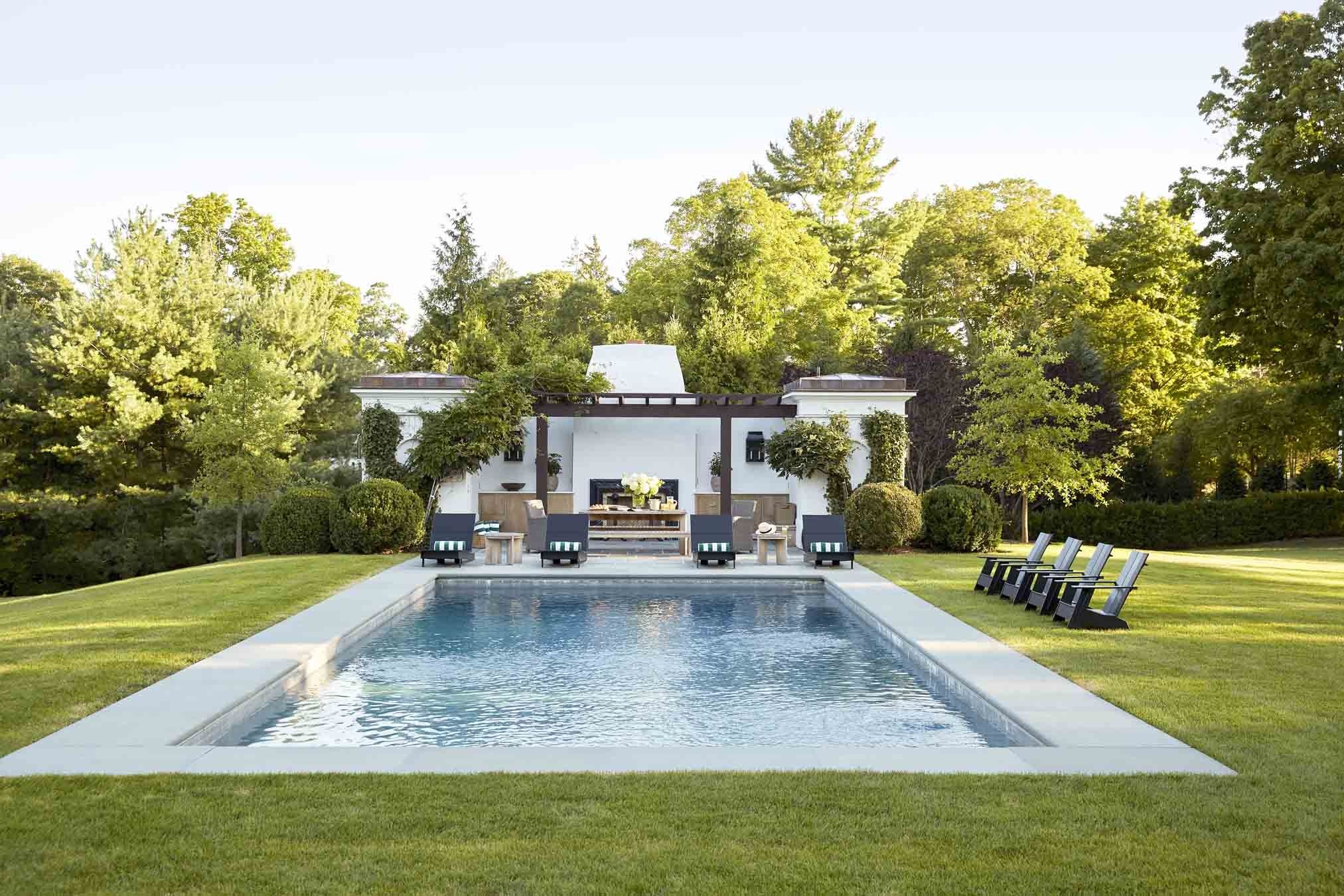 Garden with a large pool surrounded by chairs