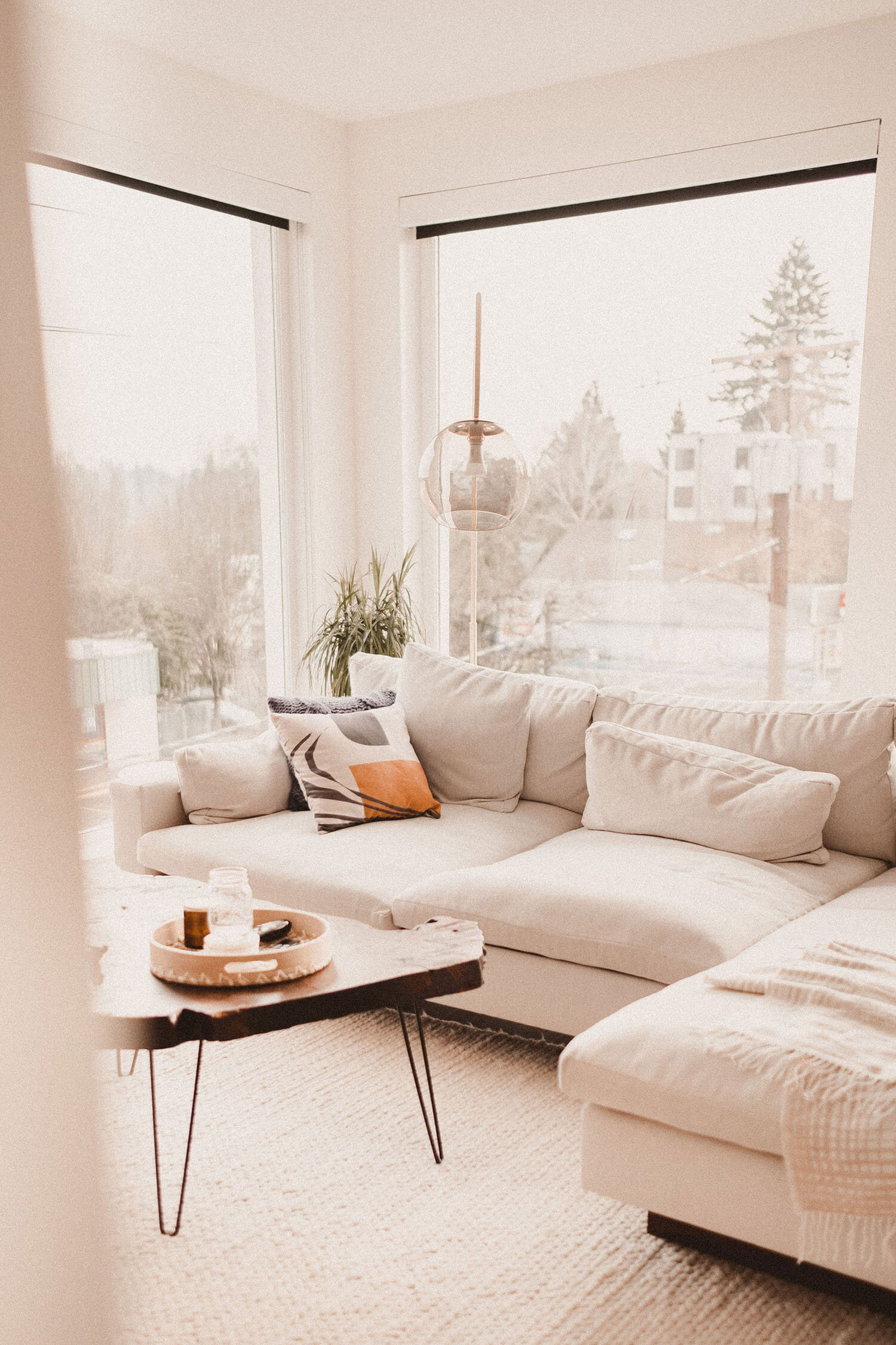 Cream-colored minimalist living room with large windows