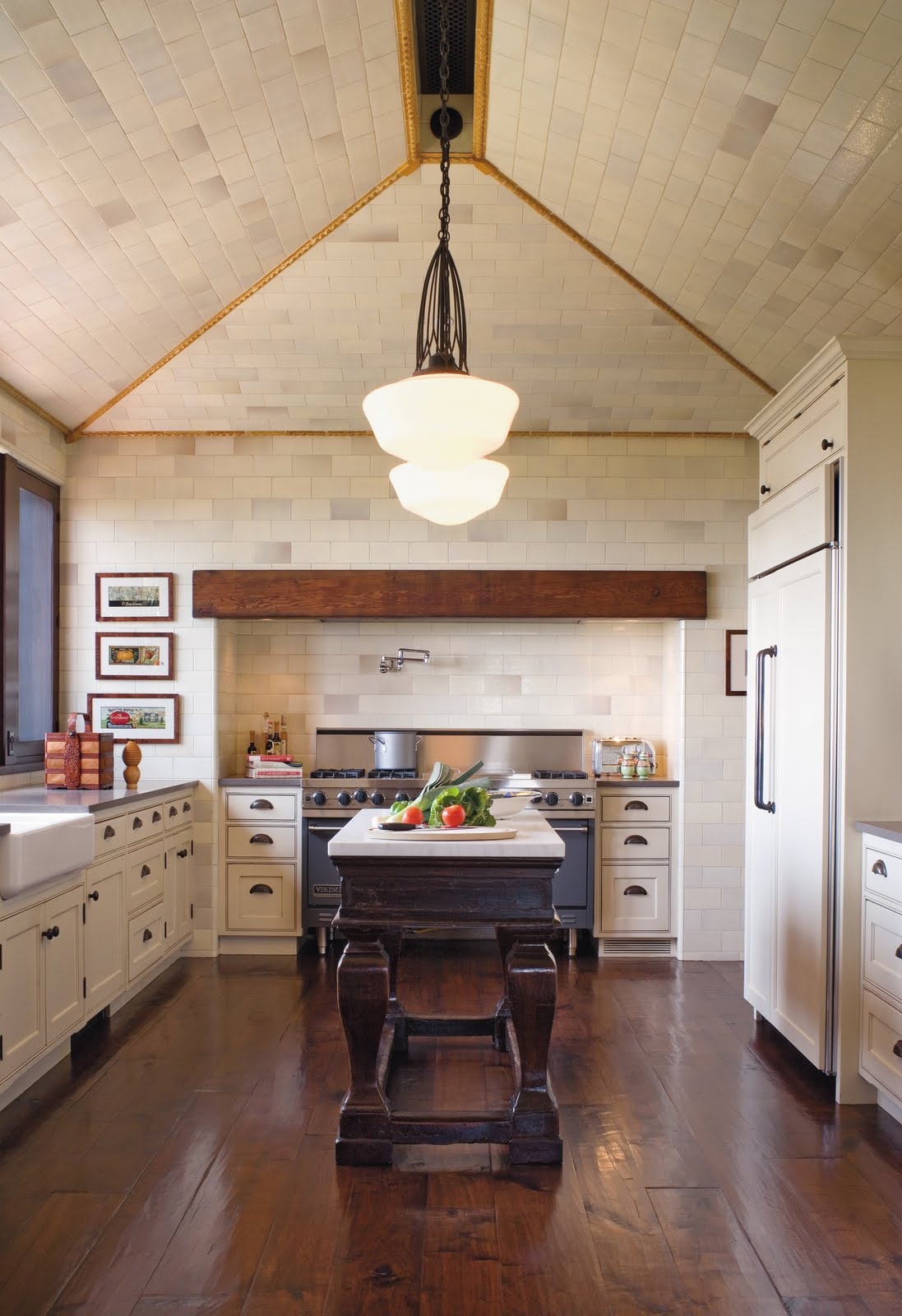 Dark kitchen island surrounded by cream furniture
