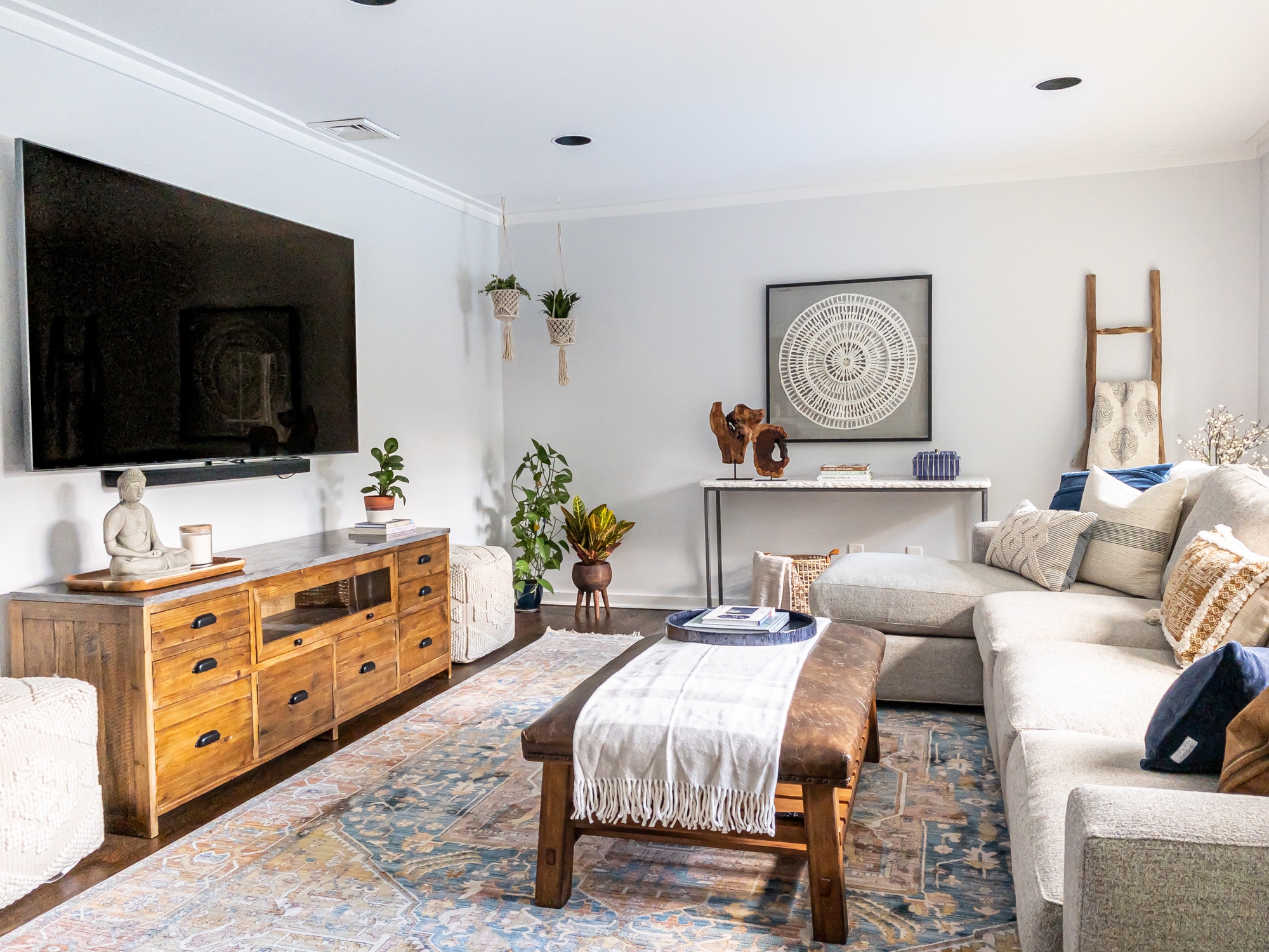 Minimalist bohemian living room with large TV and couch