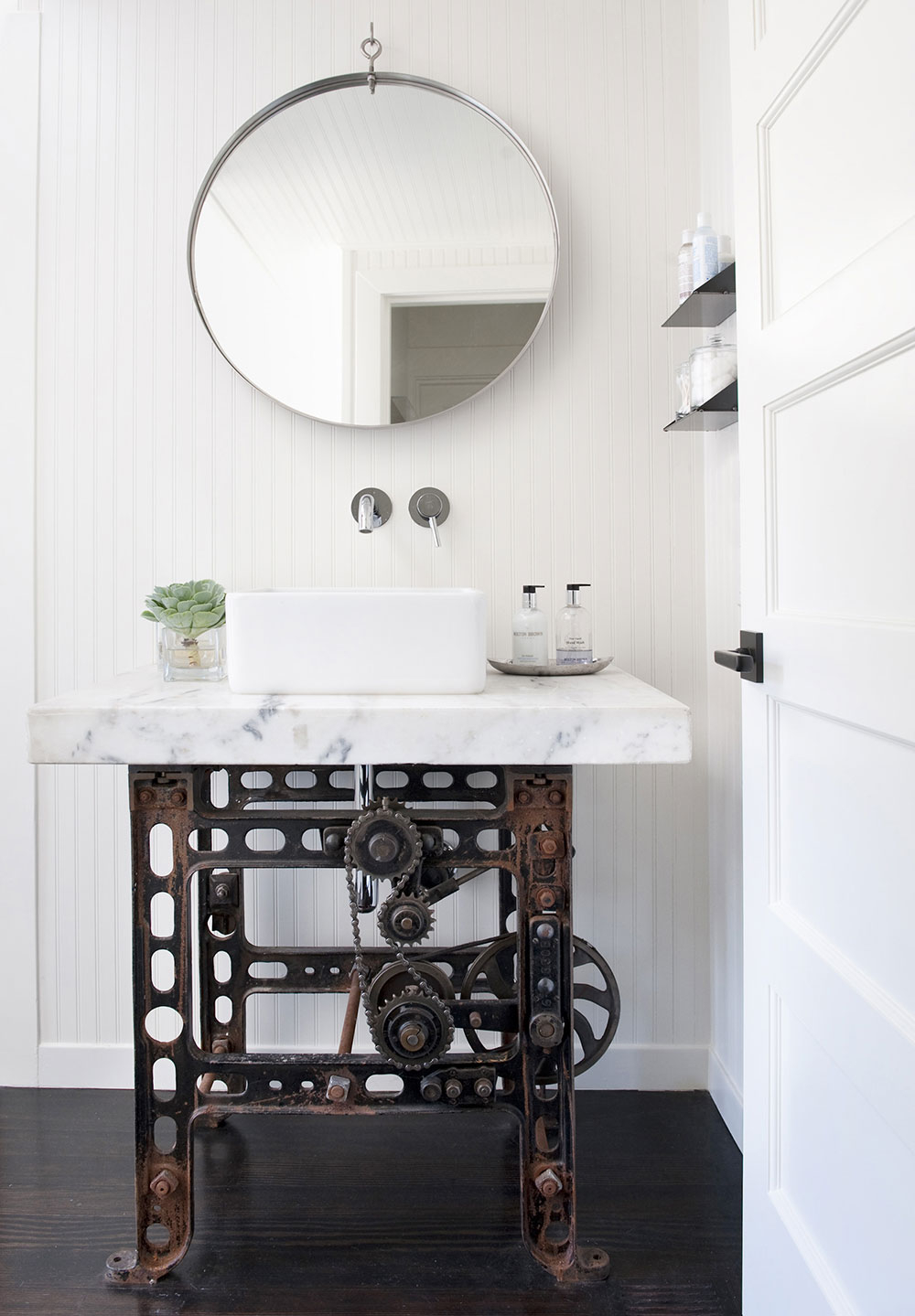 Small industrial bathroom with marble sink and antique base
