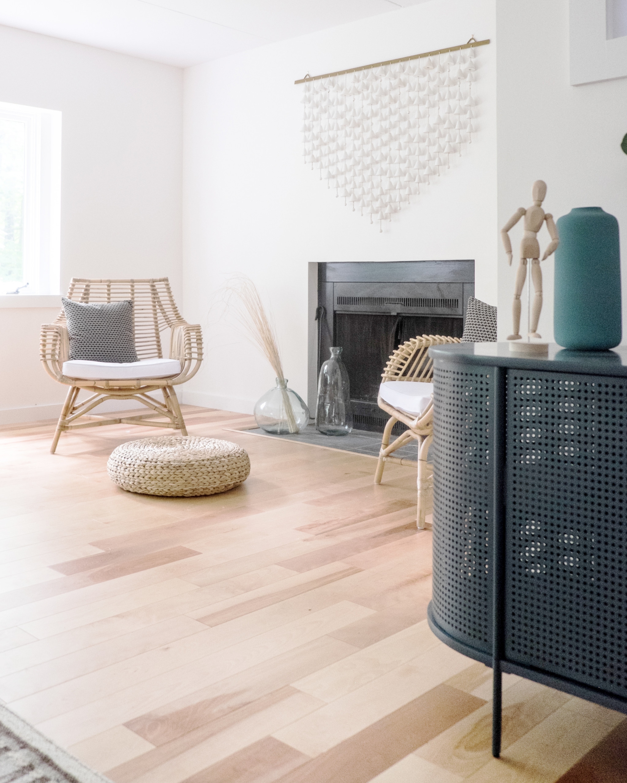 White living space with hardwood floor and wicker chairs
