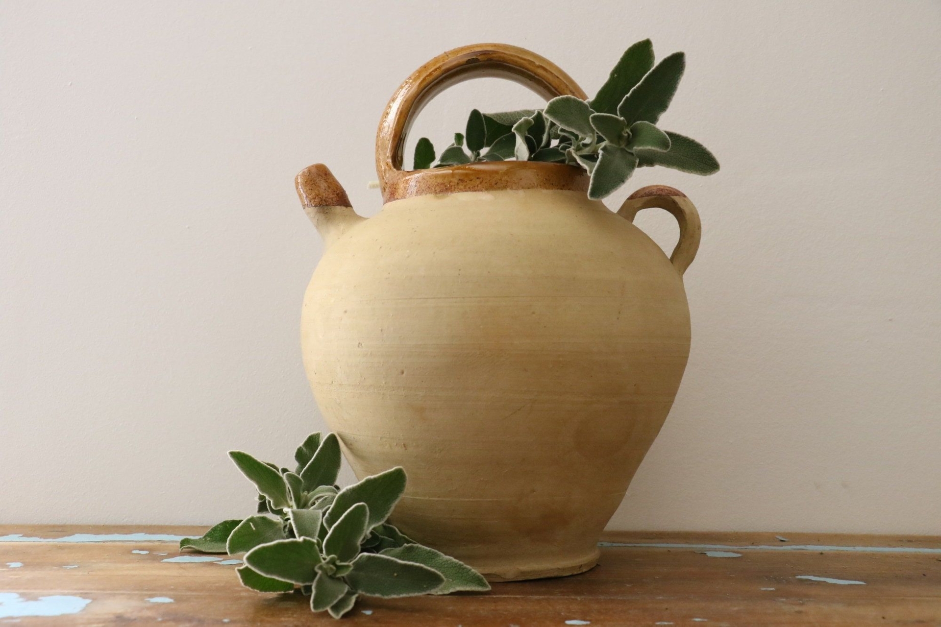 Vintage earthenware jug with yellow varnished