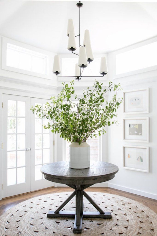 Bright Minimalist Entryway with Round Table and Greenery