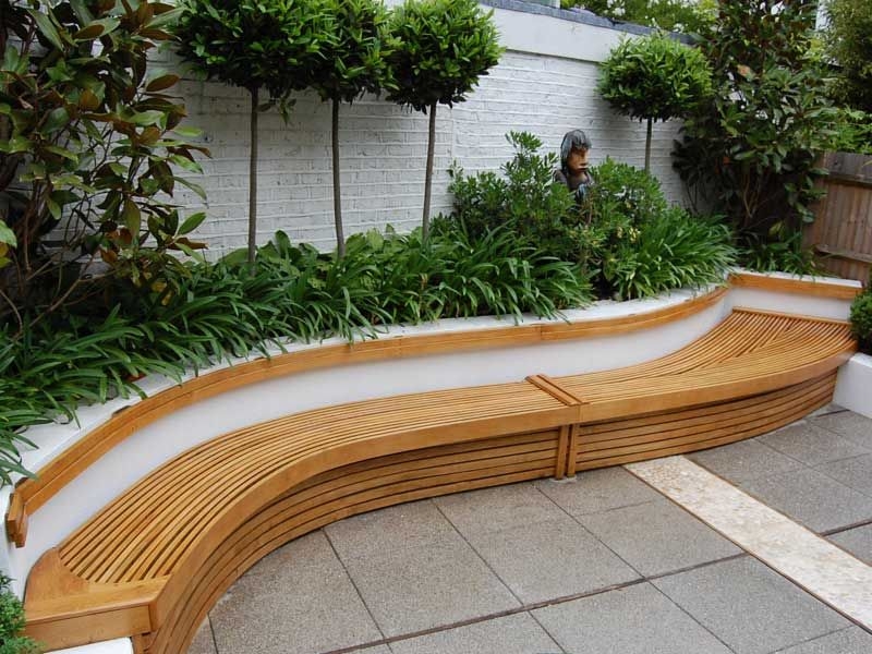 Curved Wooden Bench with Plant Border in Garden
