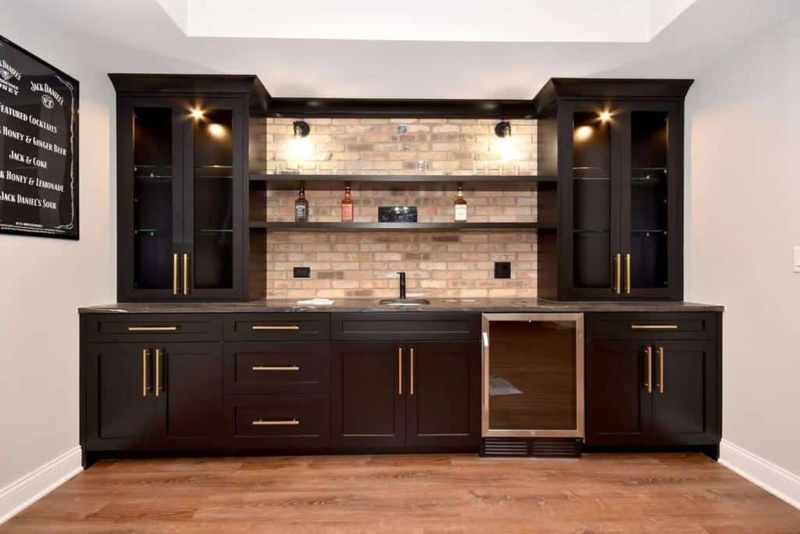 Modern Basement Bar with Black Cabinets and Brick Wall