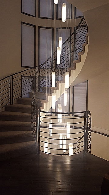 Modern Two-Story Spiral Staircase with Vertical Chandelier