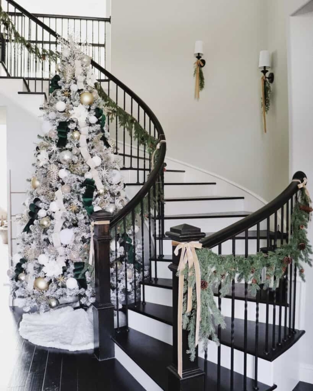 Elegant Black Staircase with Holiday Greenery and Wall Sconces