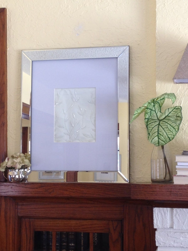 Elegant Mirrored Picture Frame Above Wooden Mantel