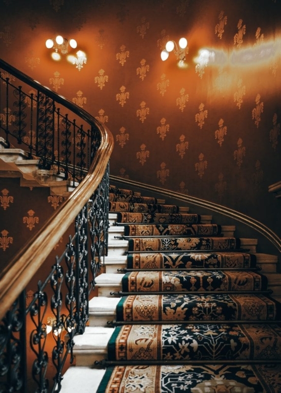 Elegant Staircase with Classic Wall Sconces and Carpet Runner