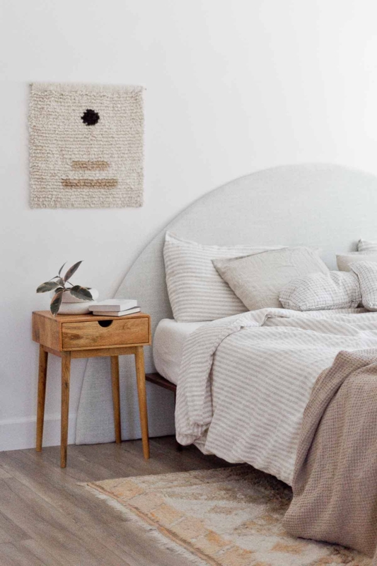 Minimalist Bedroom with Round Headboard and Wooden Nightstand