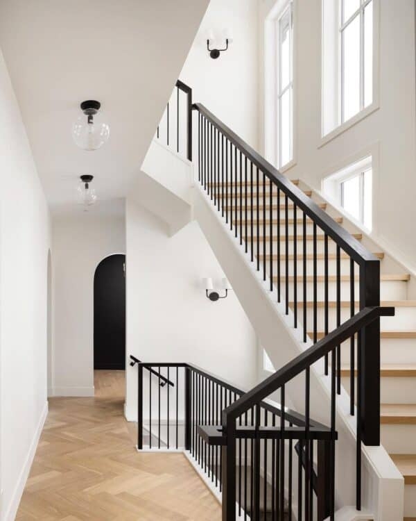 Modern Staircase with Black Metal Railings and Wall Sconces