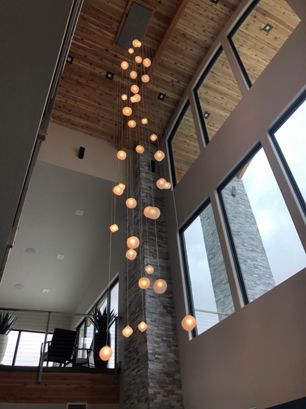 Modern Two-Story Staircase with Hanging Globe Lights