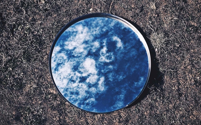 Round Mirror Reflecting Blue Sky on Earth