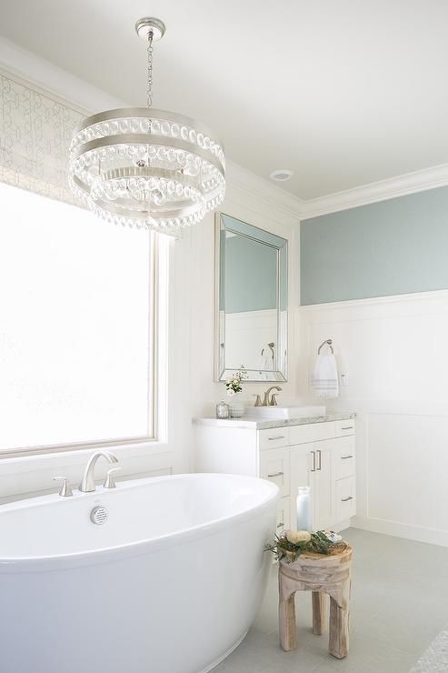Whimsical White Bathroom with Glass Chandelier and Freestanding Bathtub