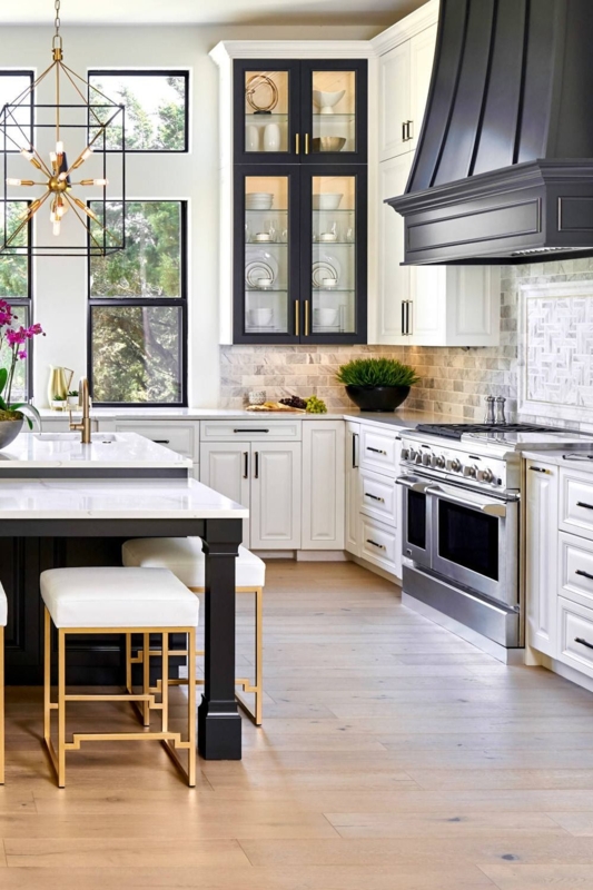 a large kitchen with white cabinets and black counter tops, along with ...