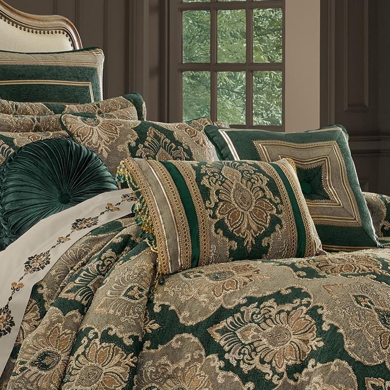 a bed with green and gold comforters in a room next to a large window