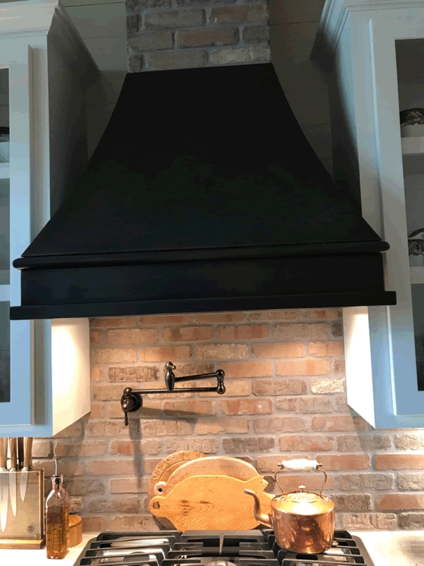 Black Farmhouse Kitchen Range Hood with Brick Backsplash