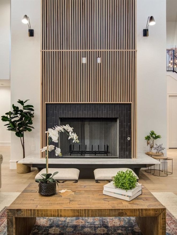 a living room with a large fireplace and two couches in front of the ...