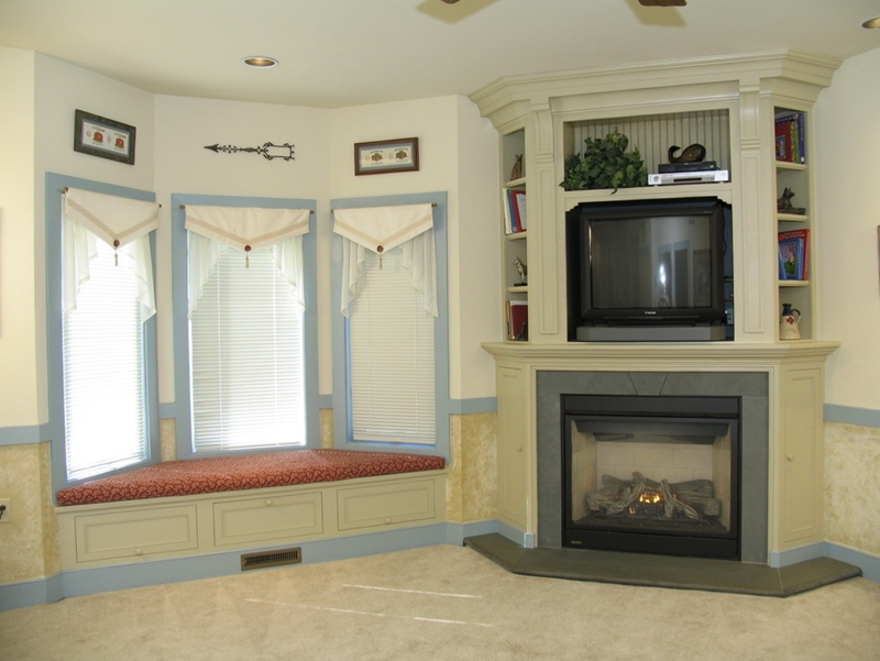 Cozy Living Room Fireplace with Built-In TV and Window Seat