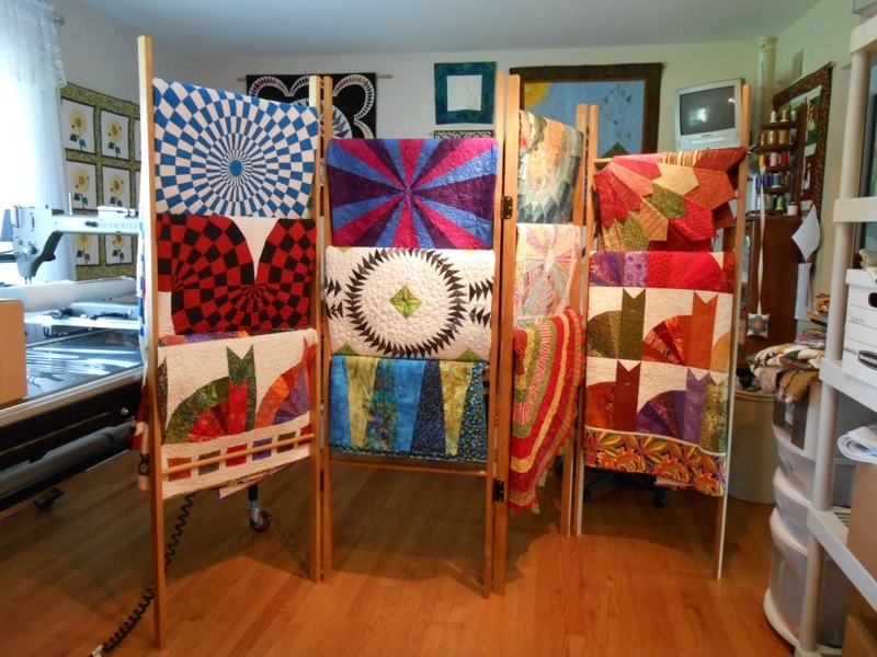 Colorful Quilts Displayed on Wooden Quilt Racks
