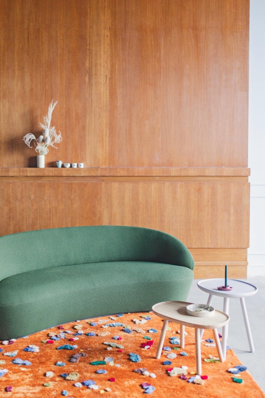 Moss Green Curved Sofa with Vibrant Orange Rug
