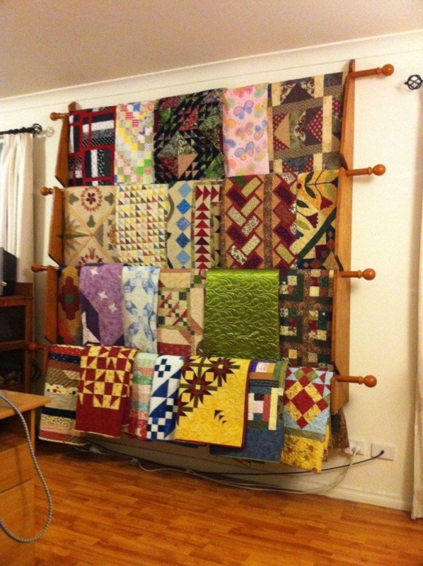 Wooden Quilt Rack Displaying Colorful Handmade Quilts