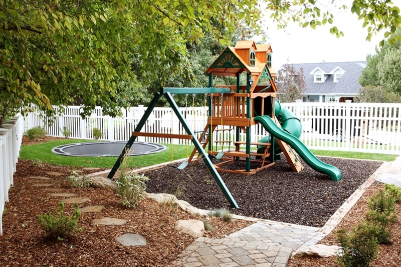 Backyard Playground with In-Ground Trampoline and Stone Path
