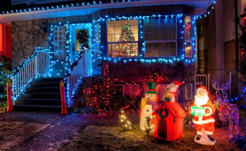 Christmas Outdoor Decor: Blue LED trim, stone facade, inflatable figures.