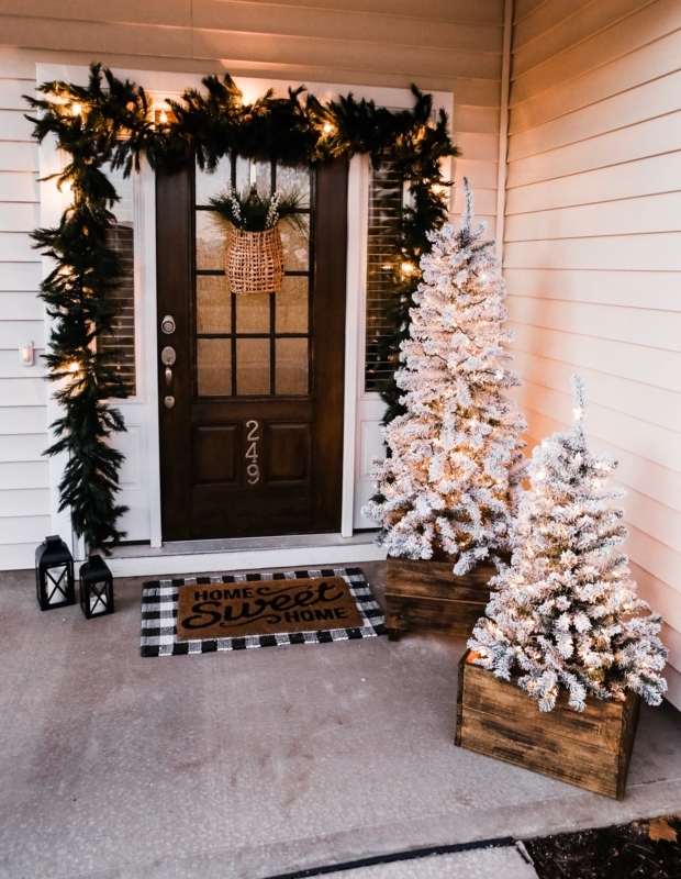 Christmas Porch Decor: Layered holiday doormats and flocked Christmas trees.