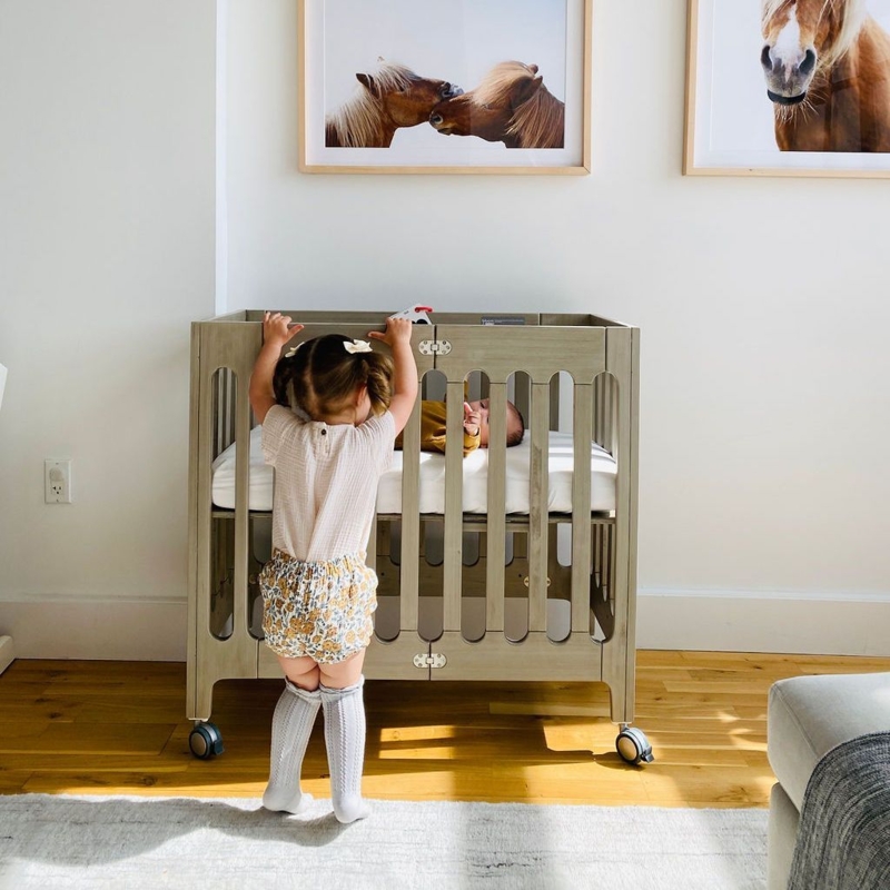Compact Mini Crib in Driftwood Gray featuring Oval Slats