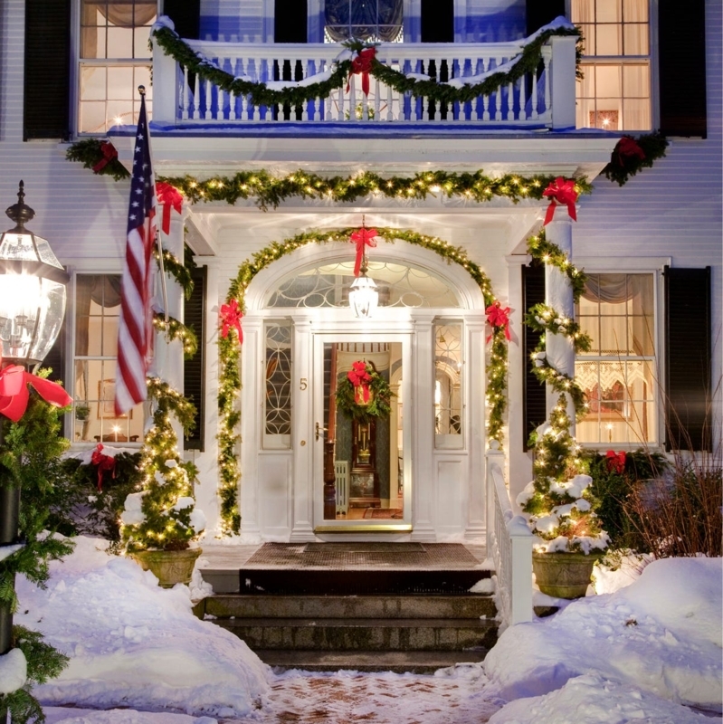 Exterior Entryway: Arched transom, spiral wrapped garland, festive red bows.