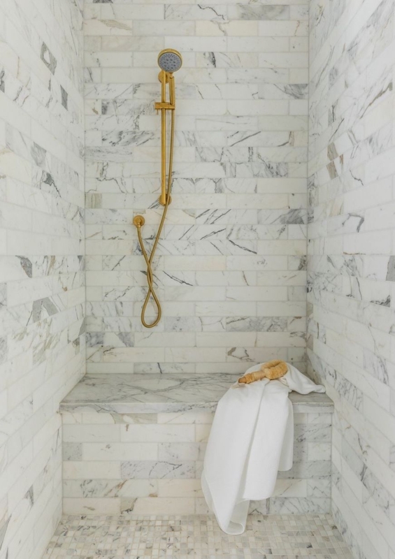 Marble Shower Bench Design with Warm Gold Fixtures