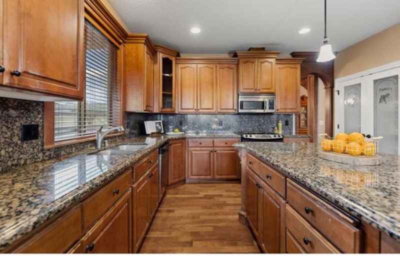 Raised Panel Kitchen Cabinetry with Full Granite Backsplash Design