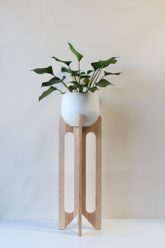 Tall Arched Plant Stand with Vertical Cutouts in Light Wood Tone.
