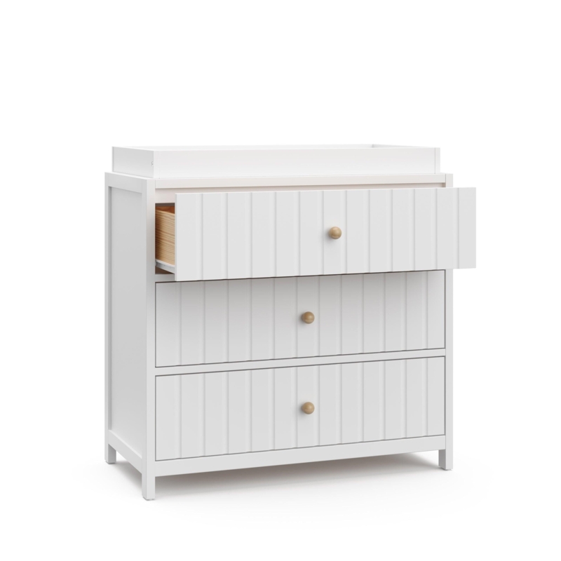 White Nursery Chest with Vertical Ribbed Drawers and Round Wooden Knobs.