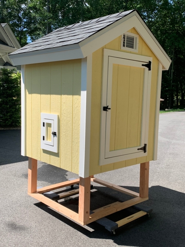 Yellow Cottage Chicken Coop with Pale Siding and Elevated Base Design