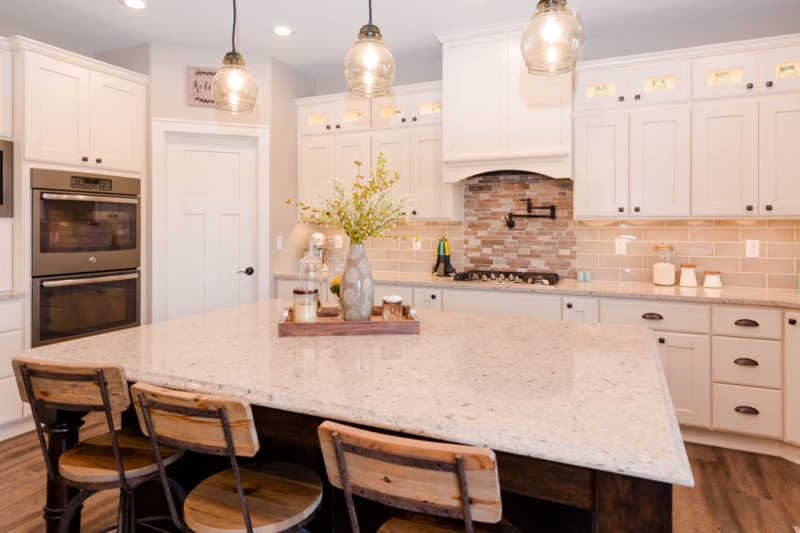 Antique Ivory Cabinets with Dark Contrasting Island and Industrial Stools