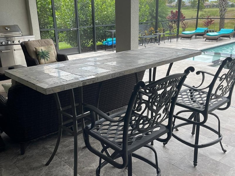 Bar Height Dining Set: Tiled Surface, Ornate Metal Stools, Footrest Rail.