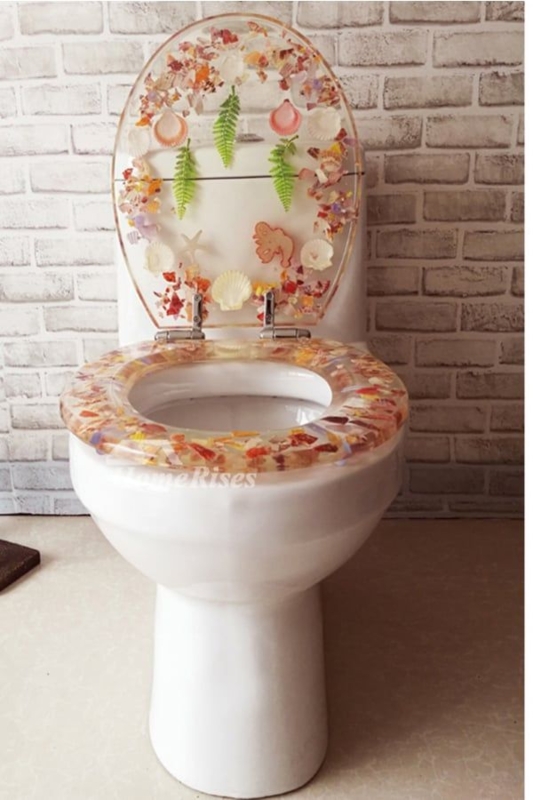 Decorative Clear Toilet Lid: Resin with Embedded Ferns and Amber Shells.