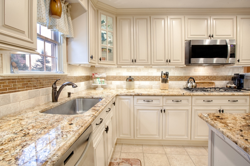 Ivory Raised Panel Cabinets with Speckled Granite and Mosaic