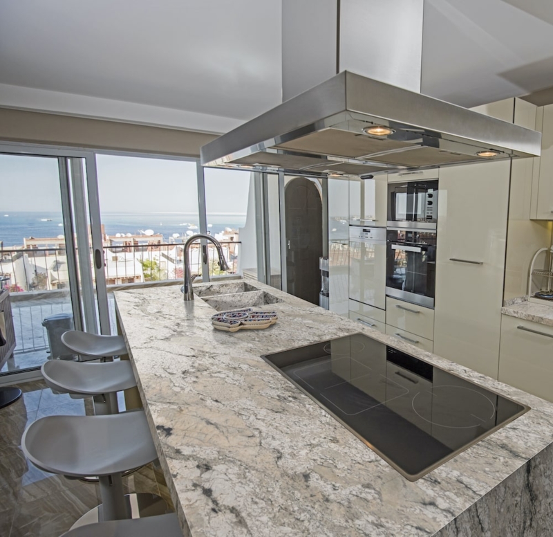 Kitchen Island with Integrated Glass Cooktop and Pedestal Stools