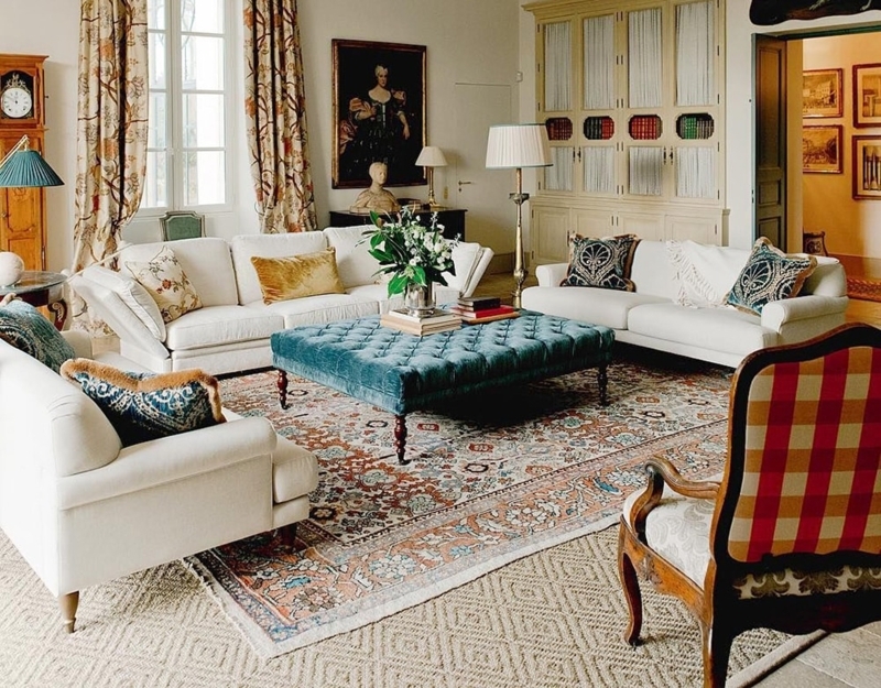 Living Room Set Featuring Tufted Teal Ottoman and Layered Rugs
