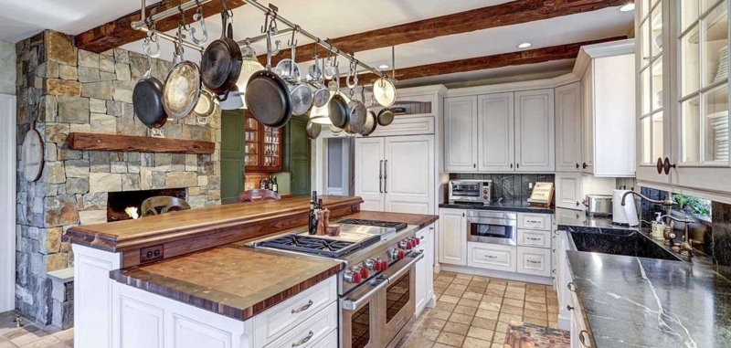 Rustic Multi-Level Kitchen Island with Hanging Pot Rack & Beams