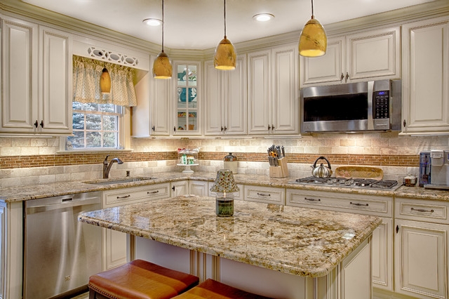 Traditional Ivory Glazed Cabinetry with Amber Pendant Lights