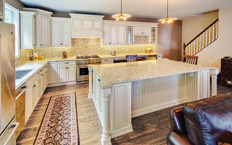 Traditional Ivory Raised Panel Cabinets with Oversized Granite Island